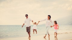 Happy Young Family have Fun Walking on Beach at Sunset