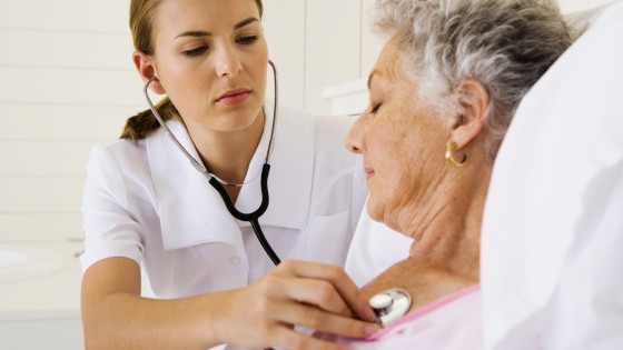 Nurse checking woman's heartbeat