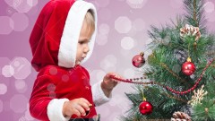 15763799-pretty-Santa-Claus-baby-decorating-Christmas-tree-on-bright-festive-background-Stock-Photo